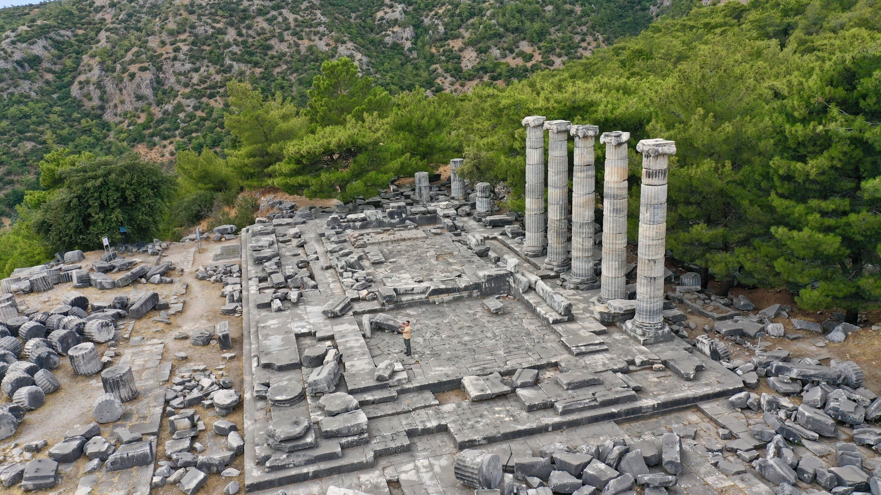Ancient ruins with columns and scattered stone blocks.
