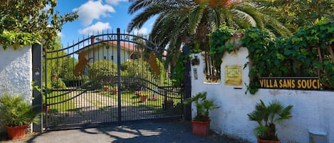 A gated entrance with a sign reading "Villa Sans Souci".