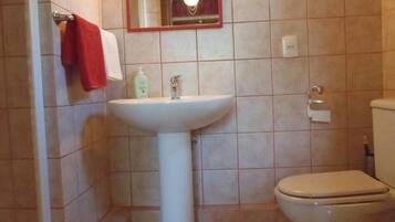 Ein Badezimmer mit einem weißen Waschbecken, einer Toilette und einem Spiegel über dem Waschbecken.