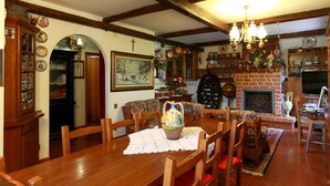 A traditional dining room with wooden furniture, a fireplace, and various decorative items. - B&B Villa Sans Souci (Civitavecchia)