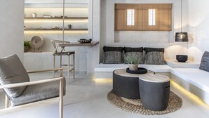 Een moderne woonkamer met een bank, salontafel en hanglamp.