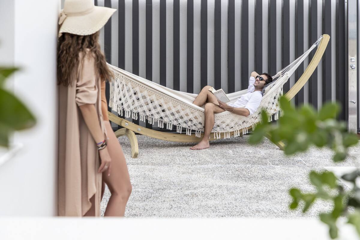 A hammock chair in a room with a striped wall and a white floor.