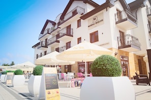 A hotel with outdoor seating, white walls, balconies, and a sign for 'Marina Mieleno'. - Marina Mielno z widokiem na Jezioro (Mielno)