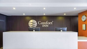 A reception desk with a Comfort INN logo, two computers, and a clock on the wall. - Comfort Inn San Luis Potosi (San Luis Potosi)