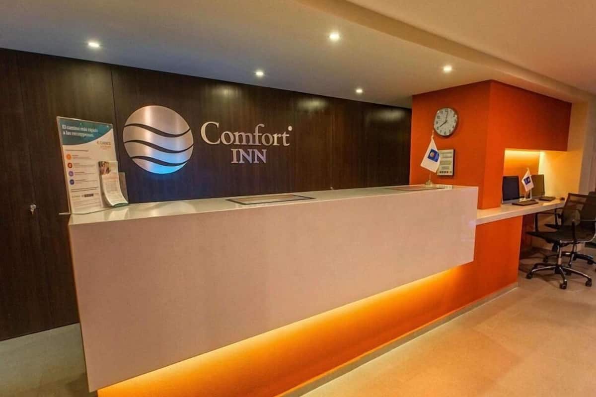 Vastaanottotiski, jossa on Comfort Inn -logon lisäksi kello ja lippu.