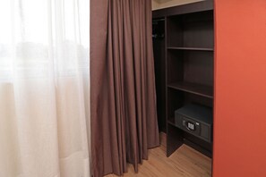 A room with a wooden floor, a brown curtain, and a black storage unit with a lock. - Comfort Inn San Luis Potosi (San Luis Potosi)