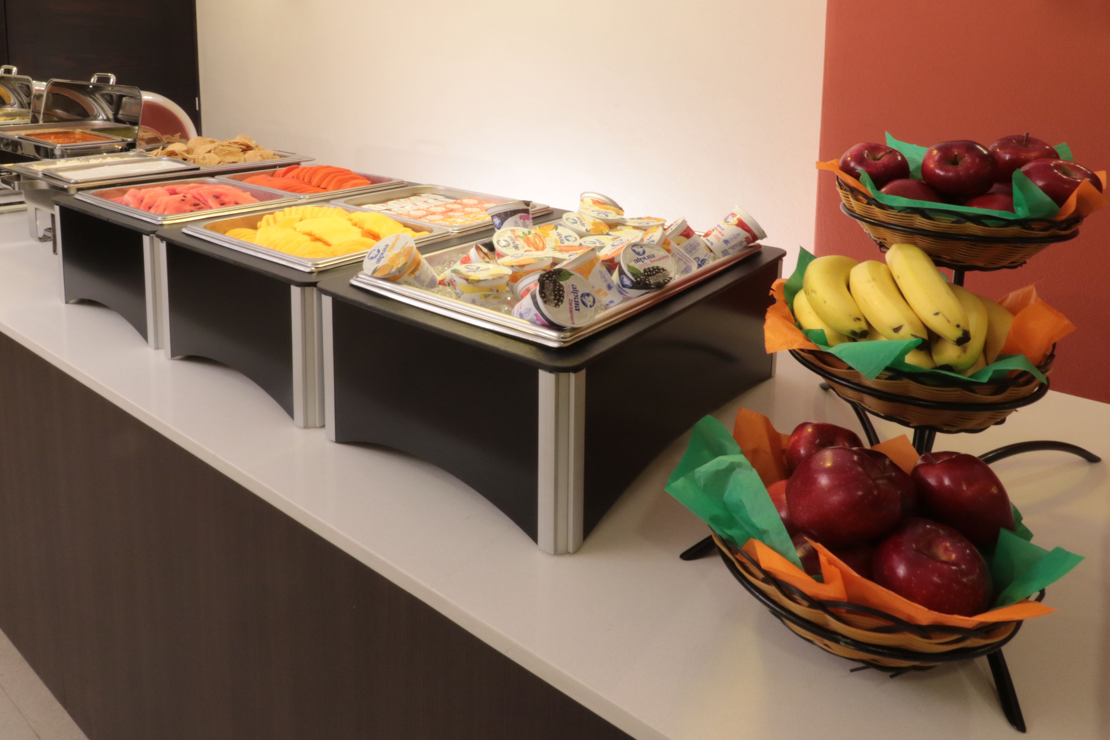 A buffet with various food items including fruits and packaged snacks.