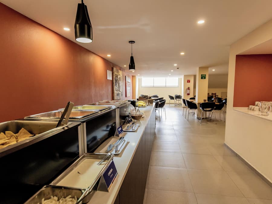 A buffet area with various food options, a seating area with chairs, and a counter with a water dispenser.