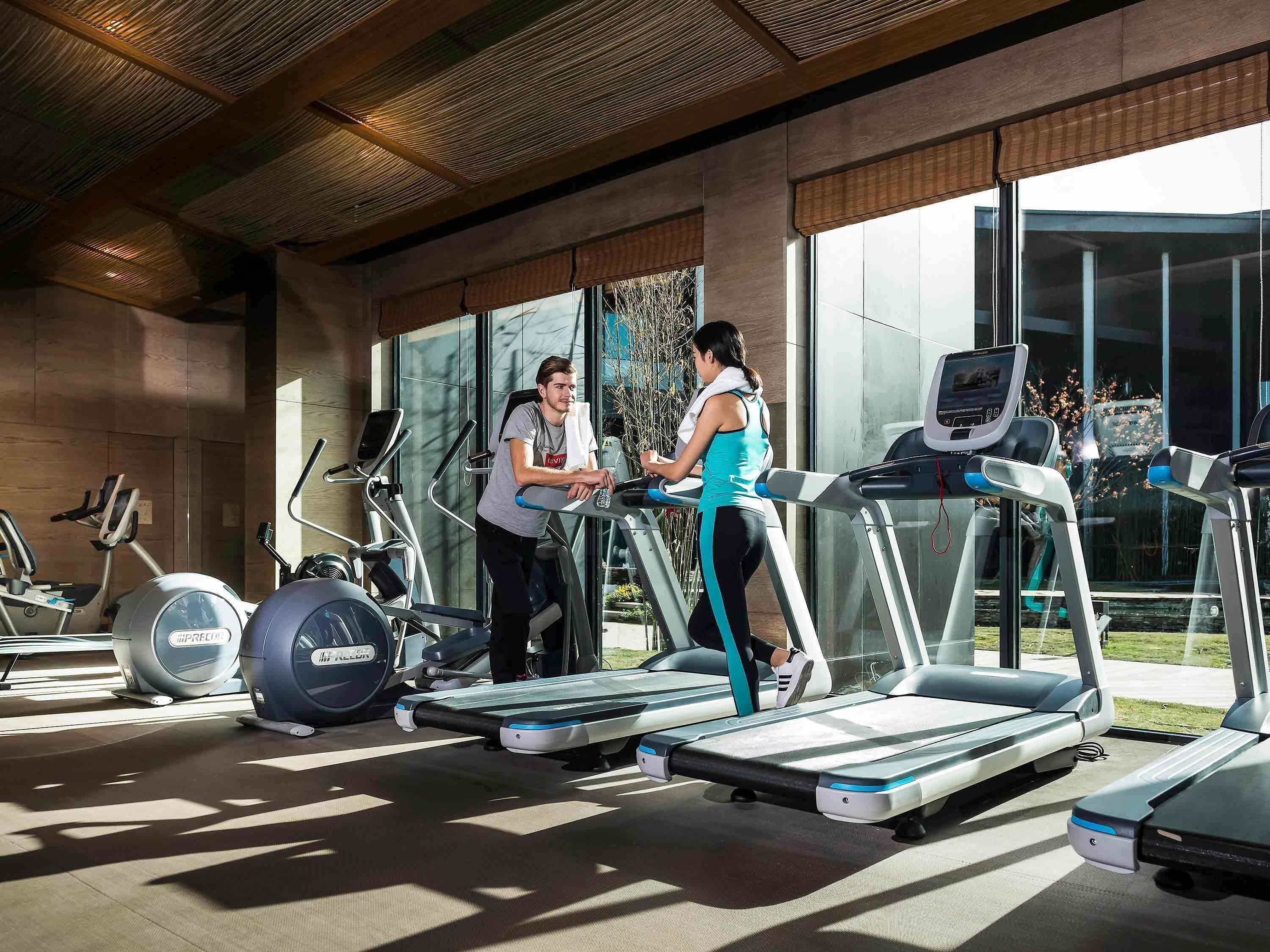 A gym with treadmills, stationary bikes, and elliptical machines.
