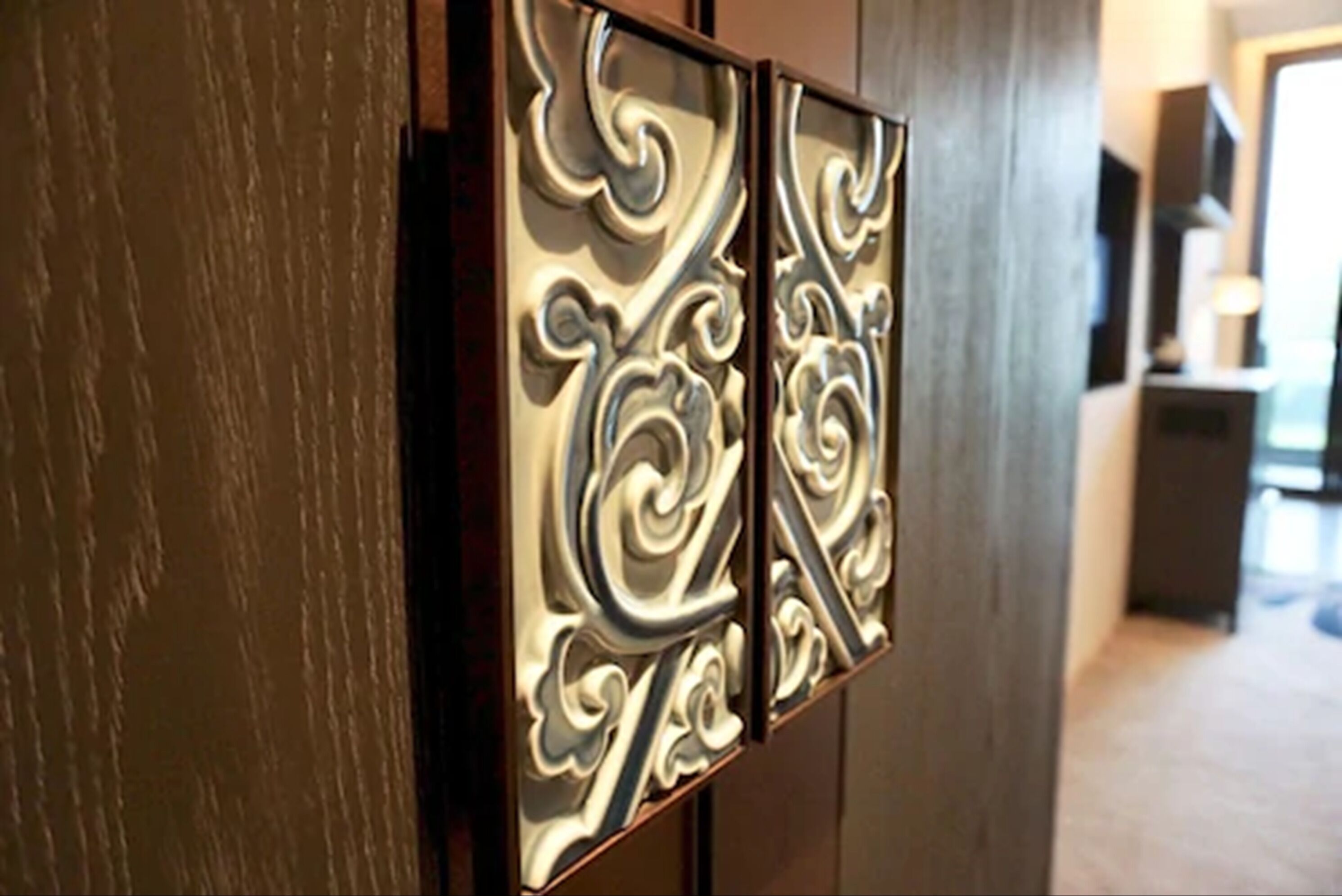 A decorative panel with intricate swirling patterns on a wooden door.