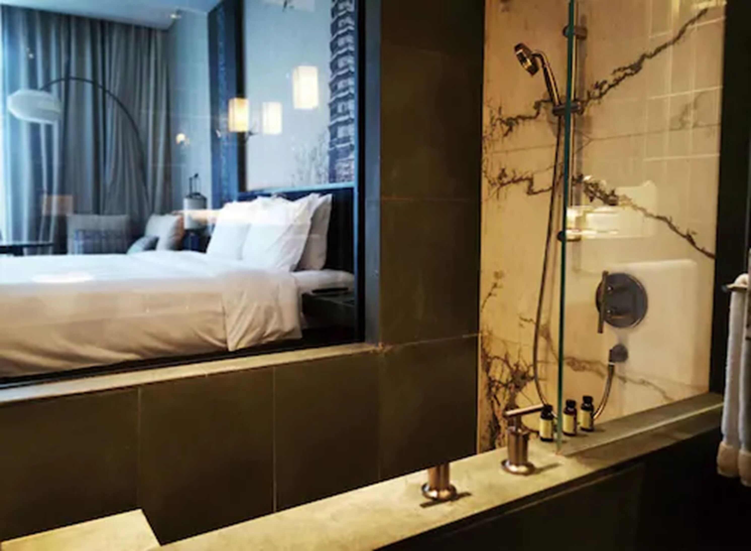 A hotel bathroom with a large mirror, a shower, and a bathtub.