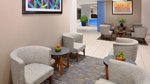 A modern lobby with grey upholstered chairs, a patterned floor, and abstract art on the walls. - Holiday Inn Express & Suites Austin Downtown - University by IHG (Austin)