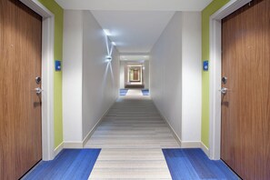 A hotel corridor with doors numbered 407 and 425, carpeted floors, and a ceiling light. - Holiday Inn Express & Suites Austin Downtown - University by IHG (Austin)