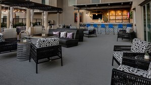 Un espace extérieur aménagé avec des meubles en osier et un bar en arrière-plan.