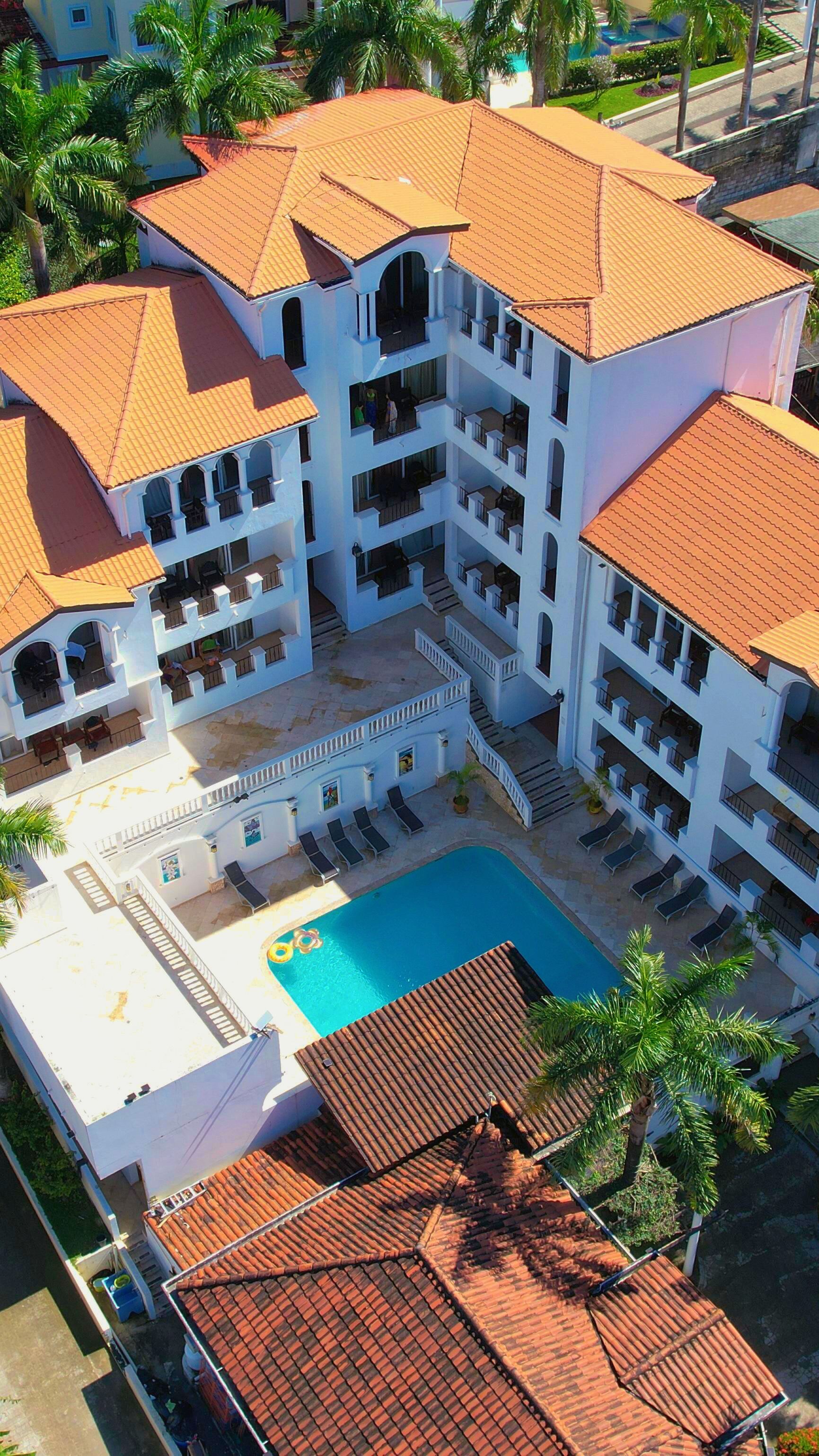 A multi-story hotel with a swimming pool, balconies, and a courtyard.