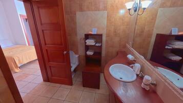 A bathroom with a sink, mirror, and towel rack.