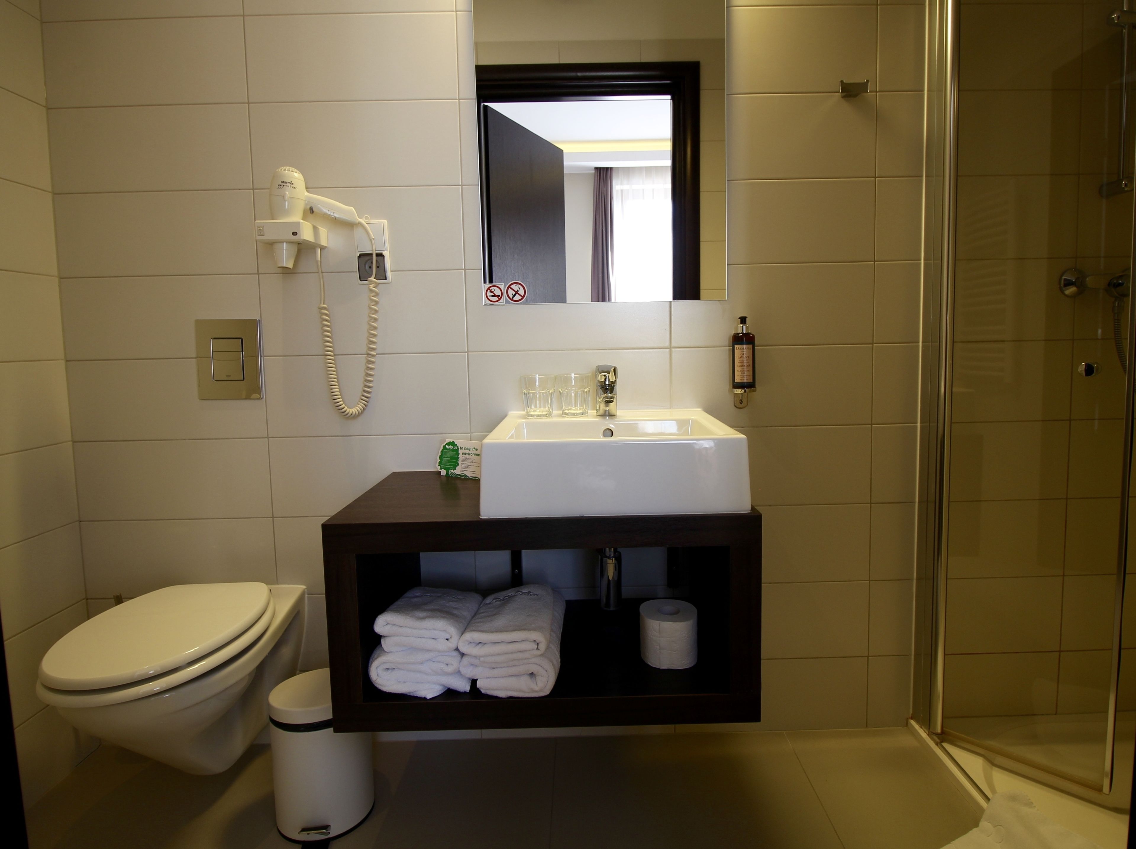 Een badkamer met toilet, wastafel en douche.