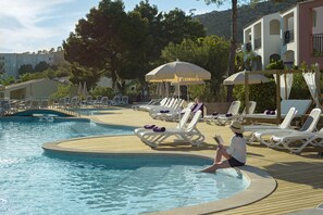 A poolside area with lounge chairs, umbrellas, and a pool. - FERGUS Club Europa (Calvia)