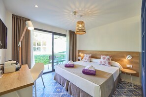 A hotel room with a bed, a desk, a chair, a lamp, and a view of the outdoors. - FERGUS Club Europa (Calvia)