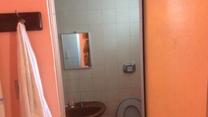 Une salle de bain avec un lavabo, des toilettes et un miroir.