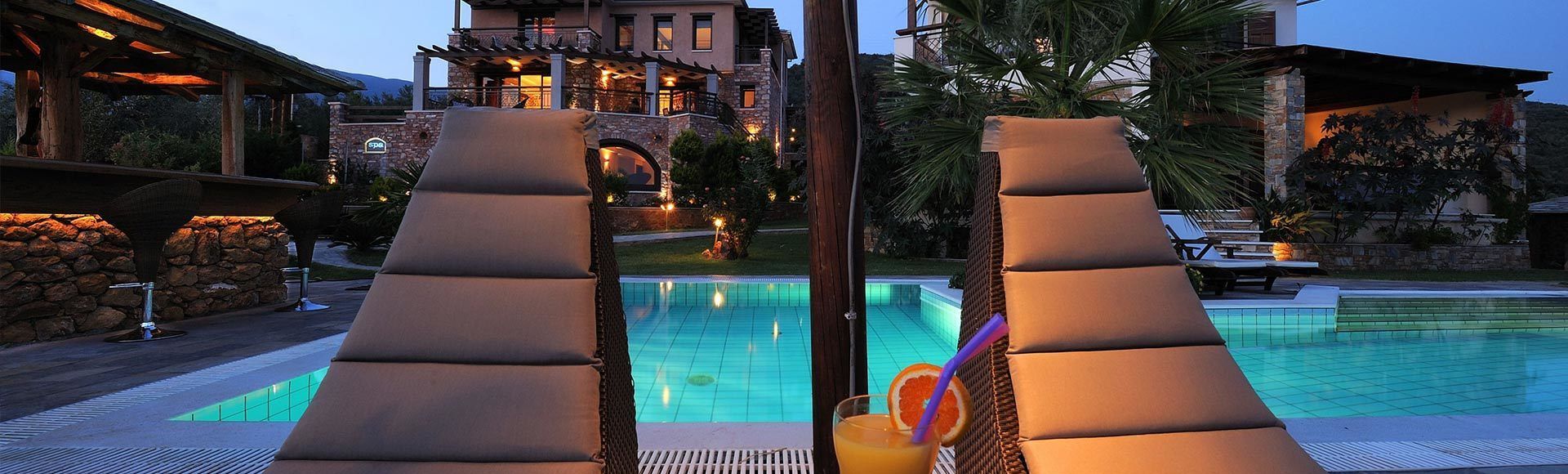 A pool area with lounge chairs and a spa sign.