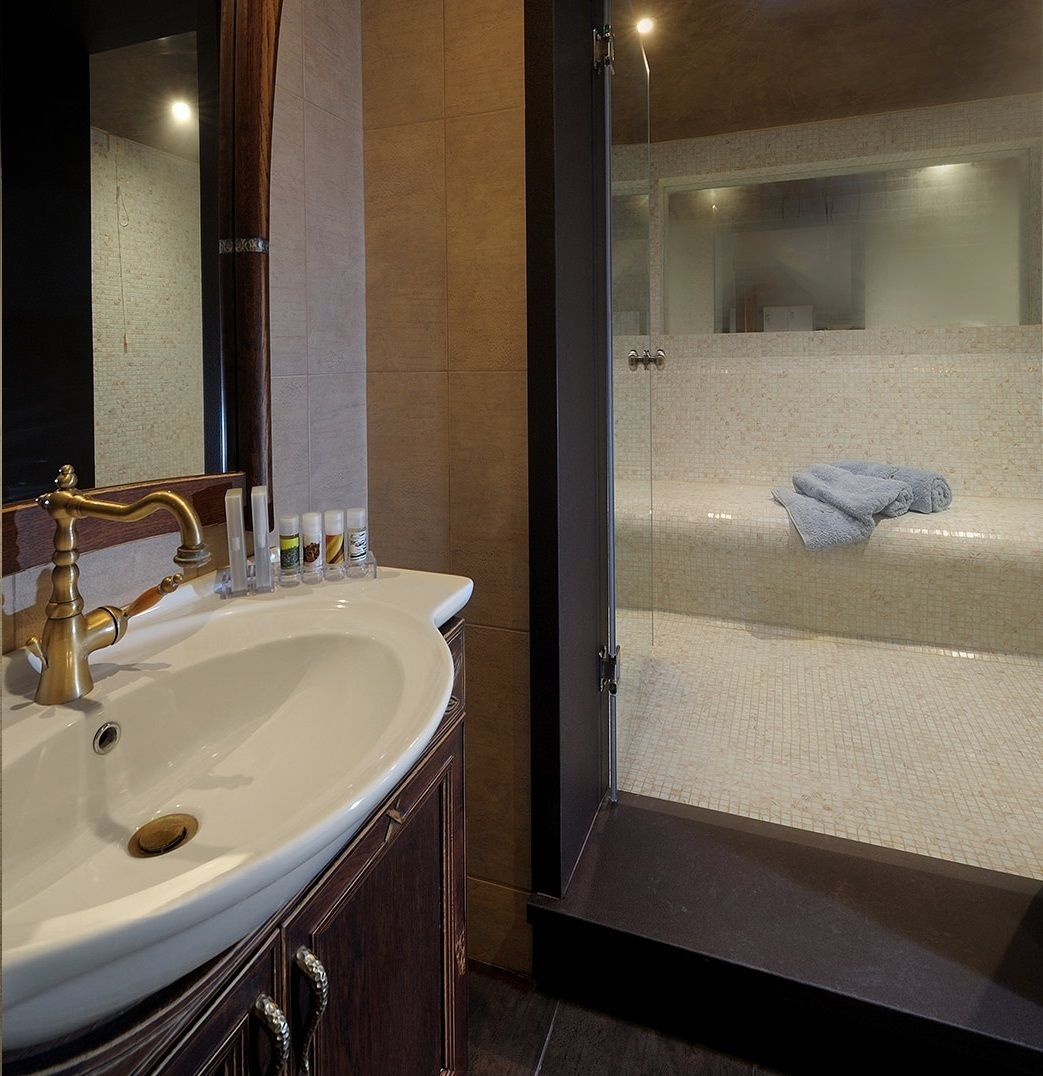 A bathroom with a sink, mirror, and toiletries.