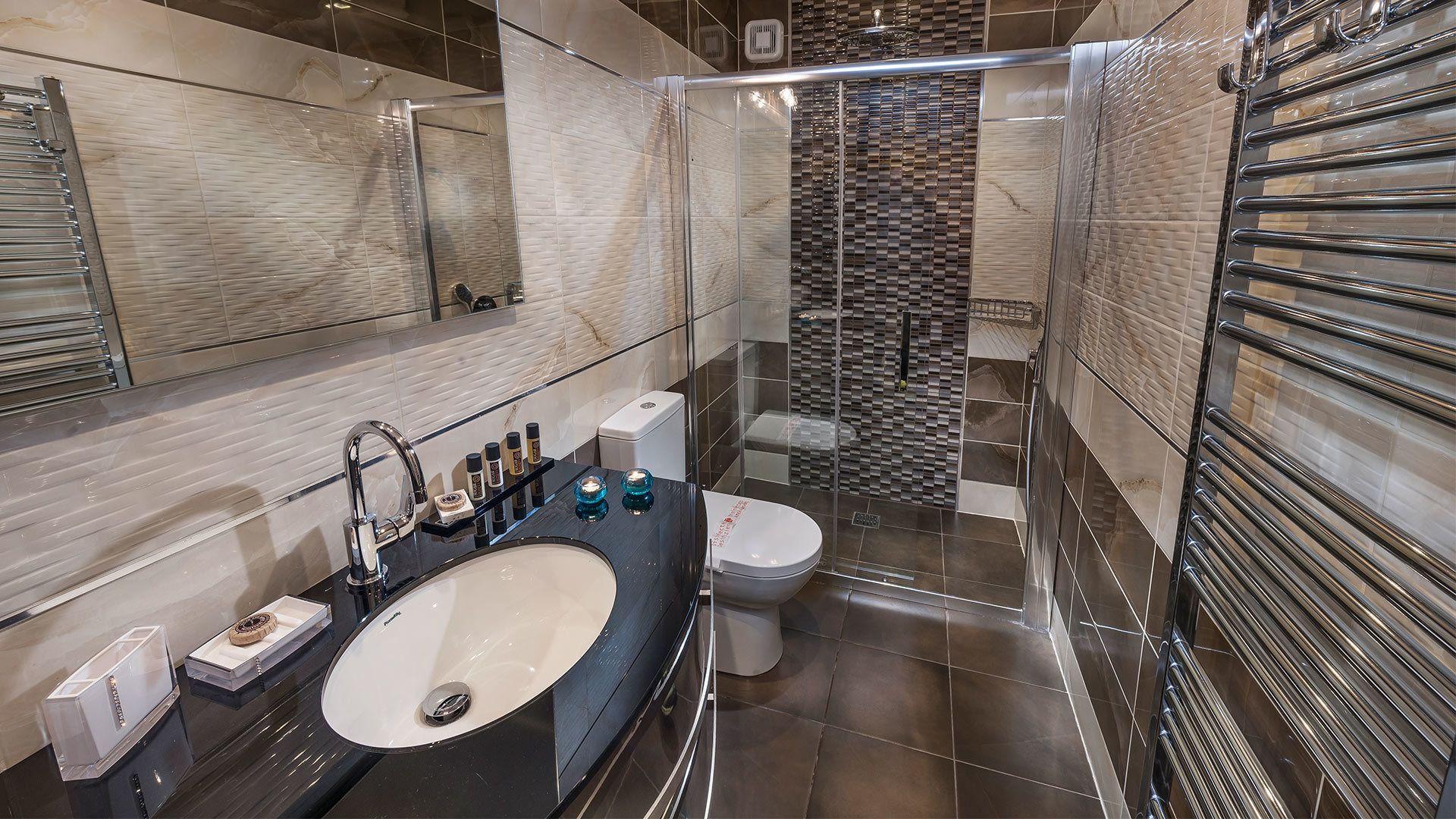 A modern bathroom with a large sink, toilet, and shower area.
