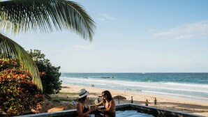 A poolside area with a view of the beach and ocean. - Palmar Beach Lodge (Bastimentos)