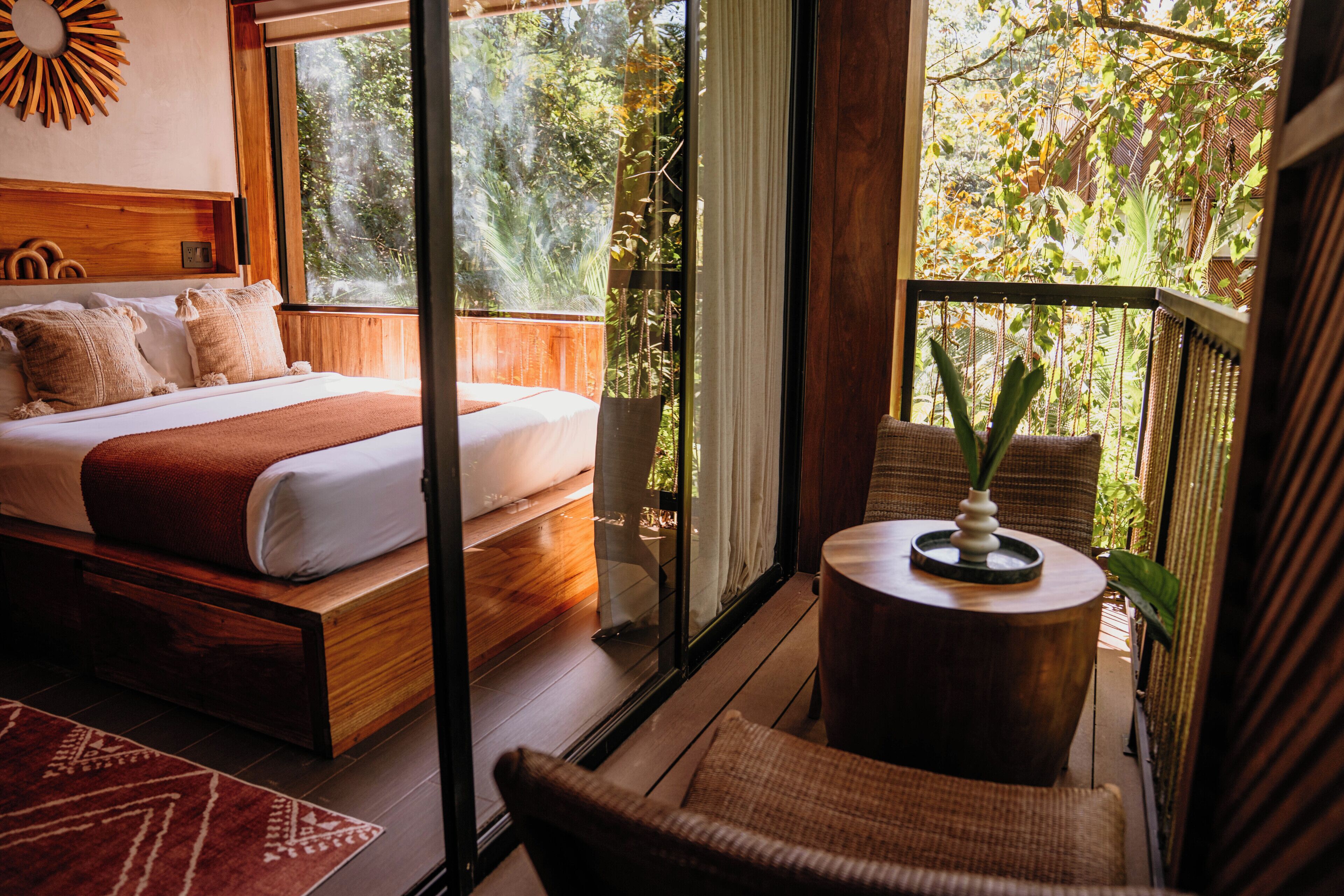 A bedroom with a bed, a small round table, and a chair.