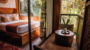 A bedroom with a bed, a small round table, and a chair.