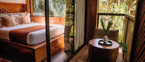 A bedroom with a bed, a small round table, and a chair.