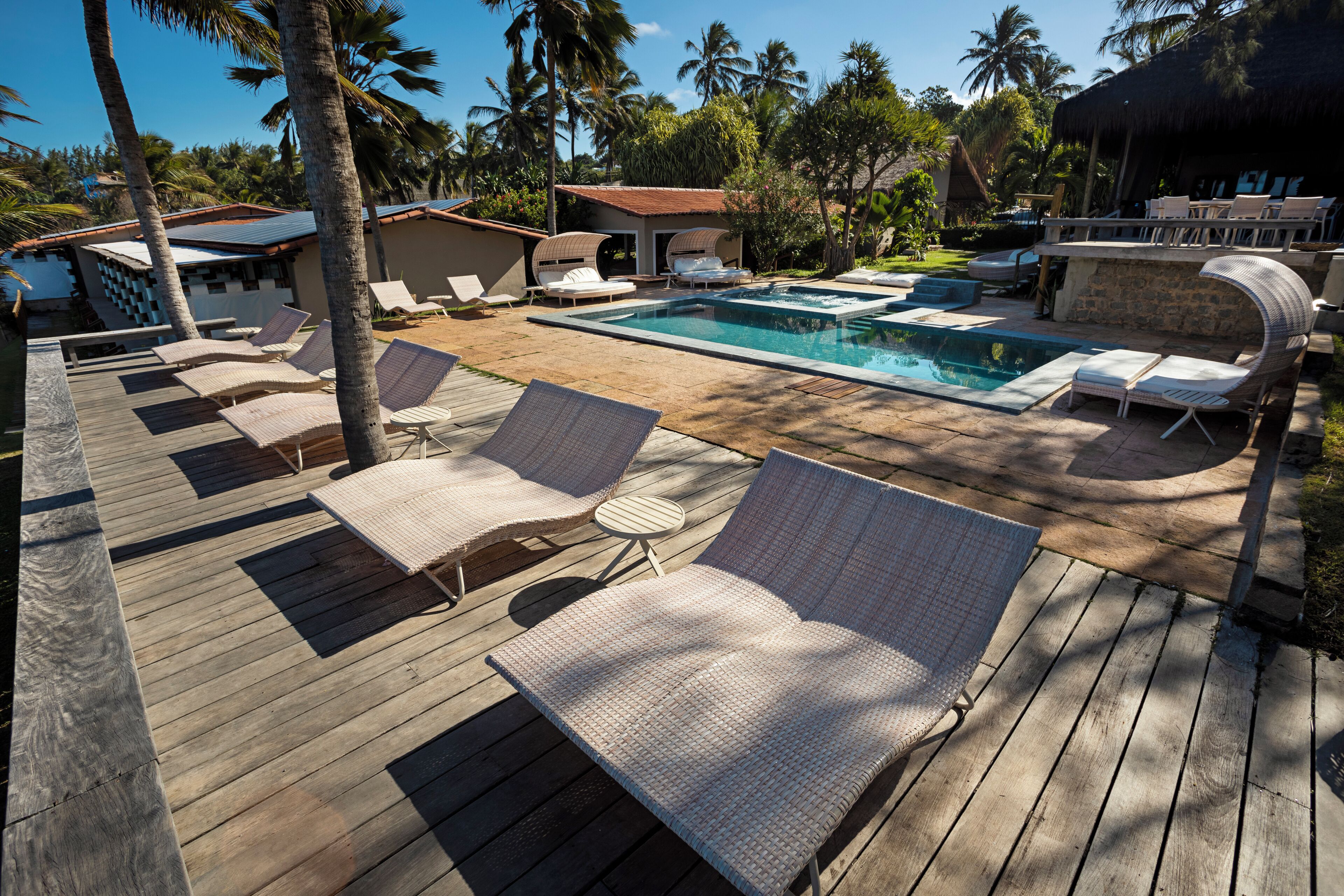 A wooden deck with lounge chairs and a swimming pool.