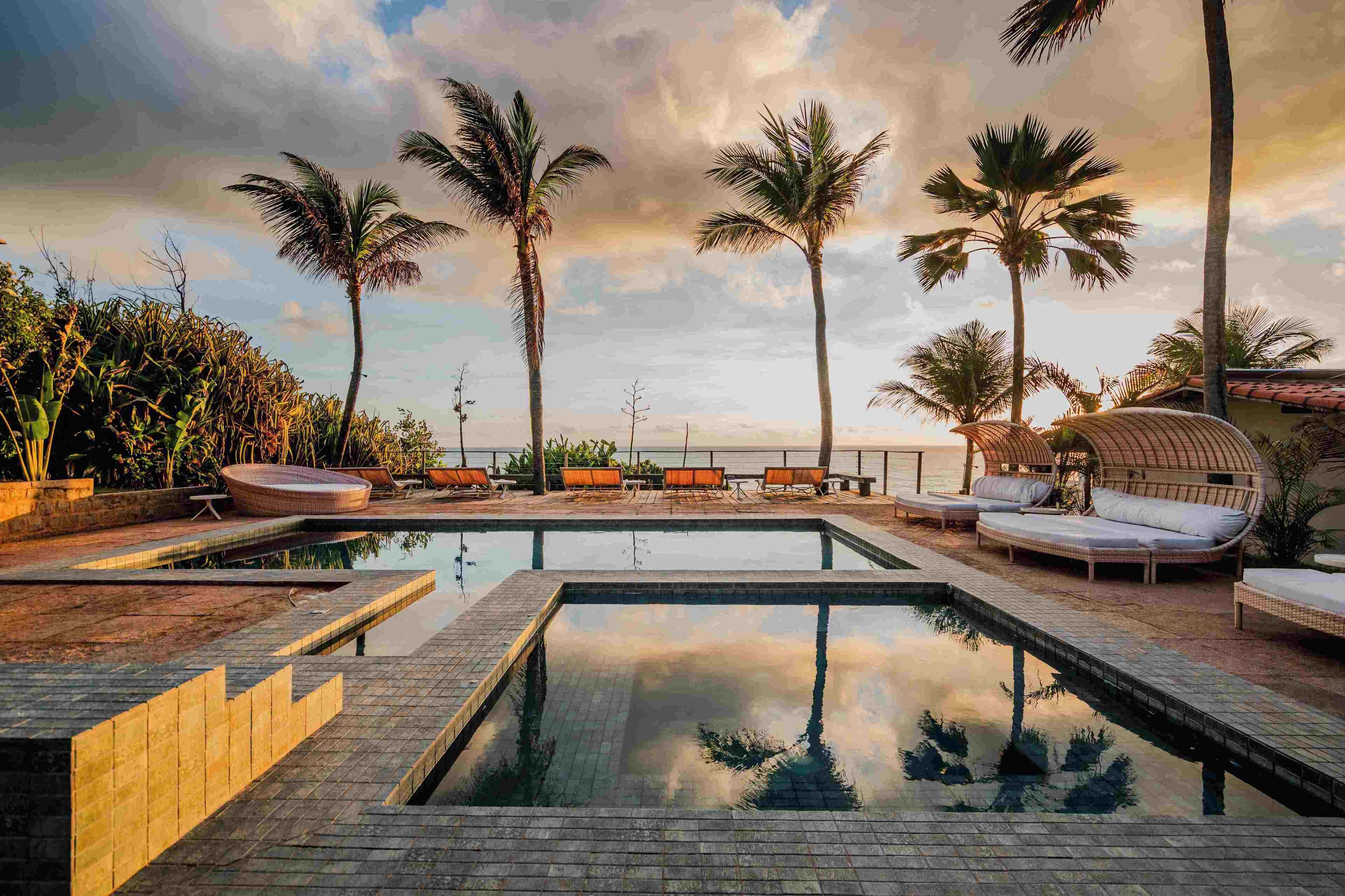 Una piscina al aire libre, sillones reclinables de piscina