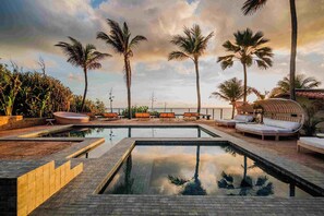 A pool area with lounge chairs and palm trees. - Hotel da Pipa (Tibau do Sul)