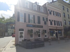 Un edificio rosa con un letrero que dice "Belloy Hôtel particulier" y mesas en la terraza.