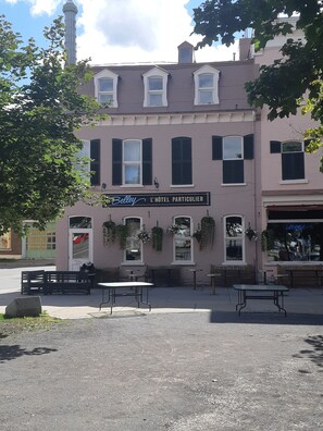 A pink building with a sign reading "L'Hôtel Particulier." - Hotel Belley (Québec City)