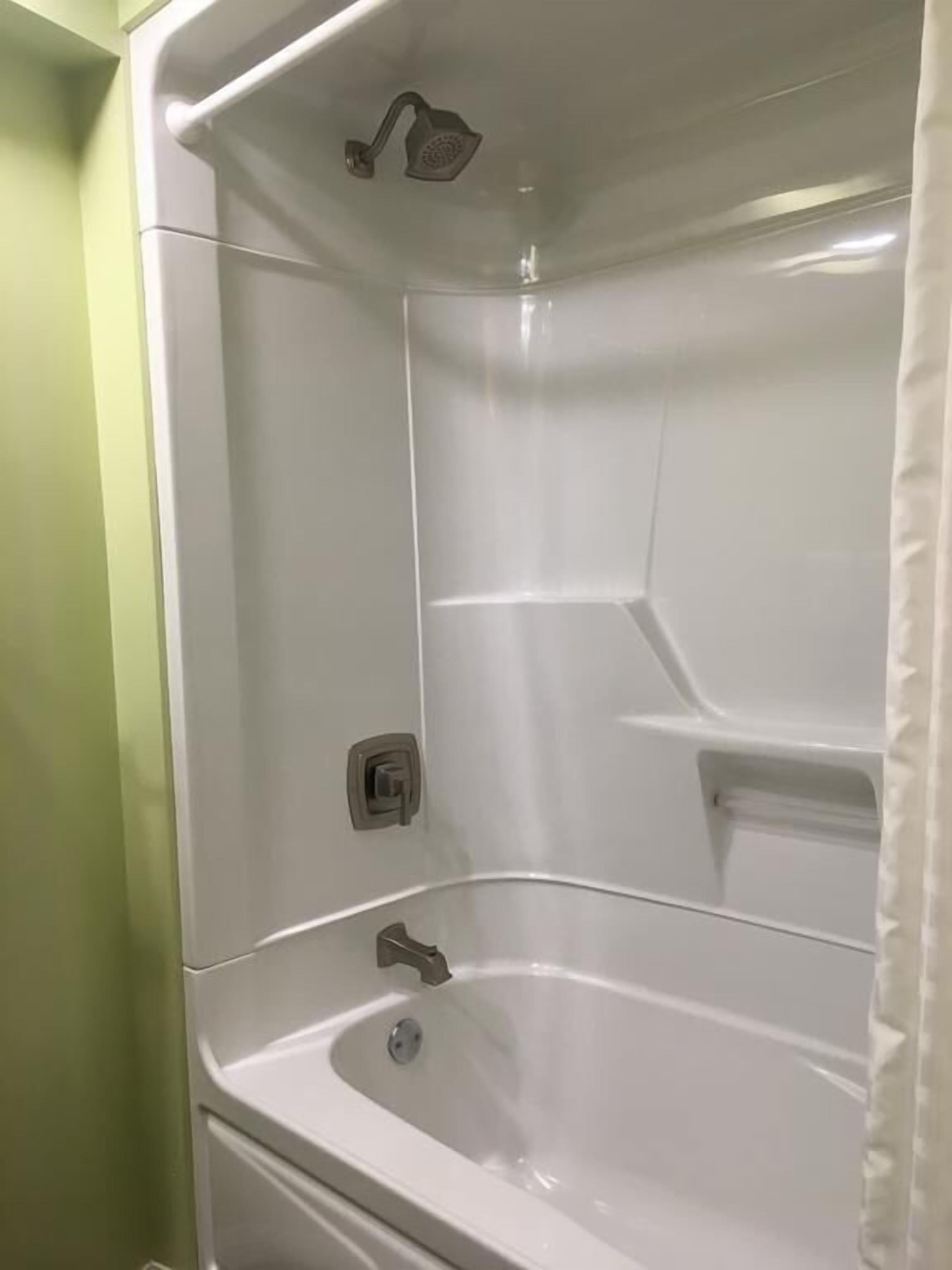 A bathroom with a bathtub, a shower, and a toilet.