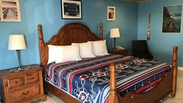 A bedroom with a wooden bed, two bedside tables, a nightstand, and a chair.