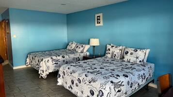 Una habitación con dos camas, un escritorio y una silla.