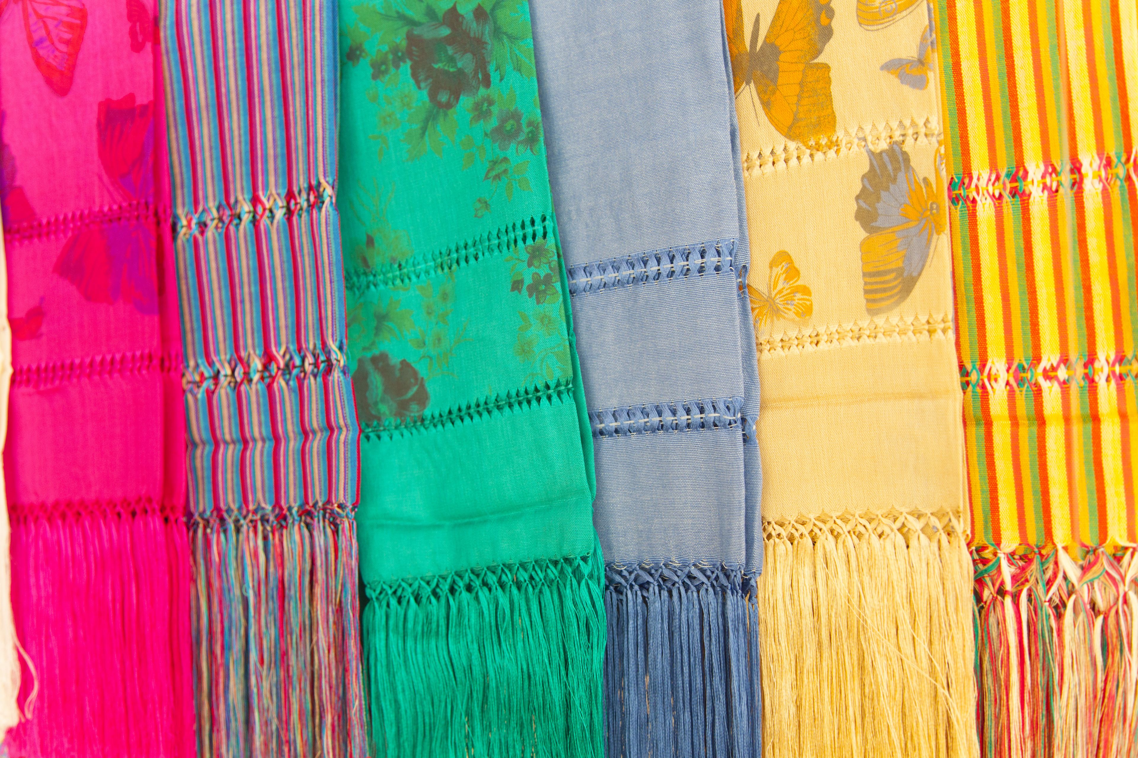 A collection of colorful fabrics with fringes.