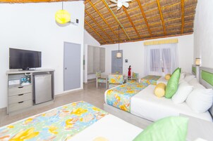 A hotel room with a TV, a desk, and two beds with floral bedding.