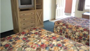 A hotel room with two beds, a TV on a wooden cabinet, and a door to the right. - Hotel Fiesta Navojoa (Navojoa)