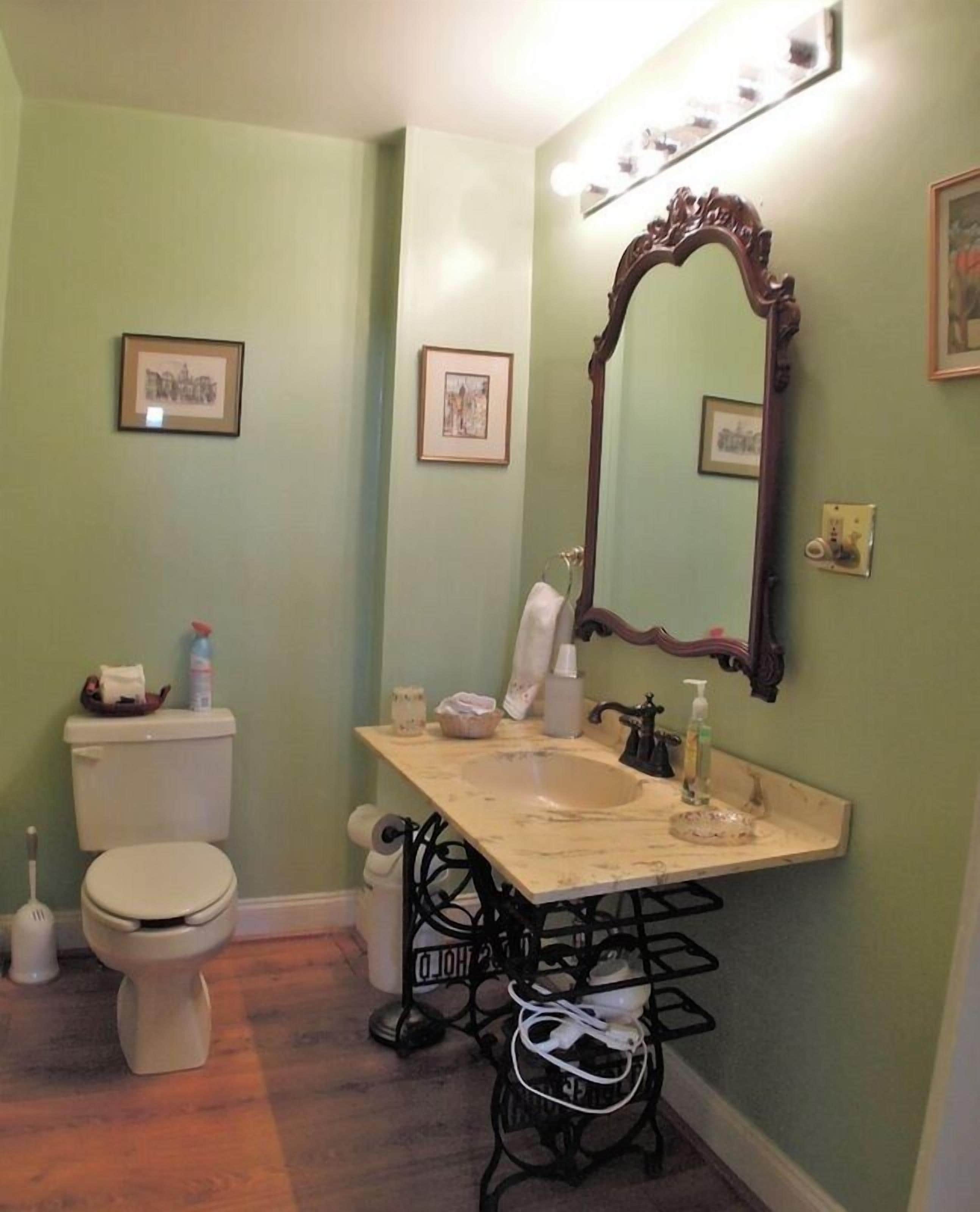 Une salle de bain avec des toilettes, un lavabo et un miroir.