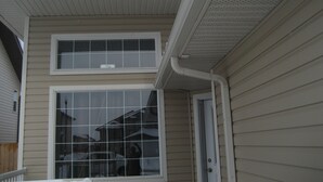 A two-story building with a gable roof and a dormer window. - Pinnacle Guest House (Grande Prairie)