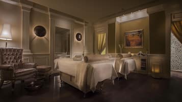 Un dormitorio lujoso con una cama grande, un chaise lounge y un espejo.