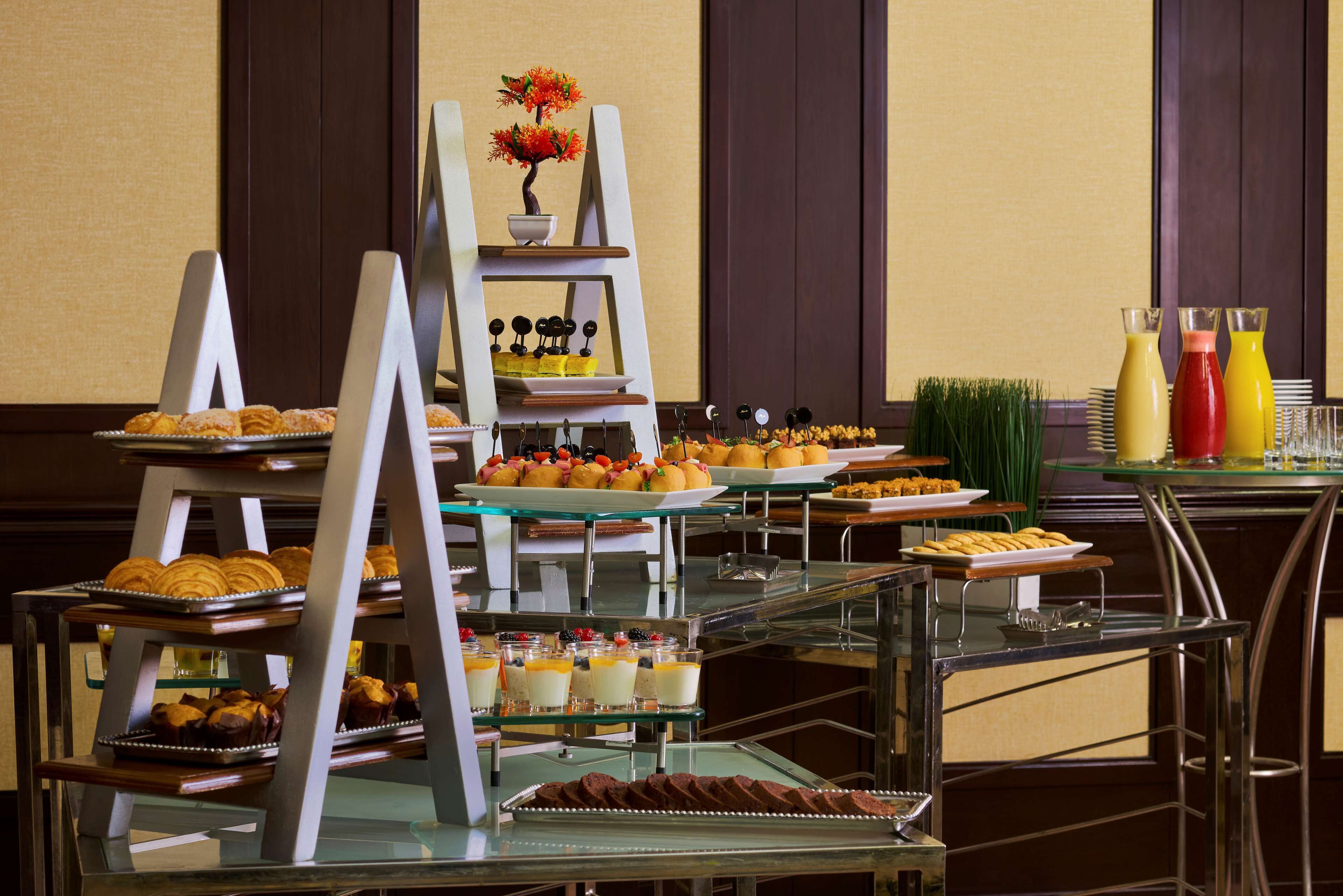 A buffet with various food items and a small potted plant.