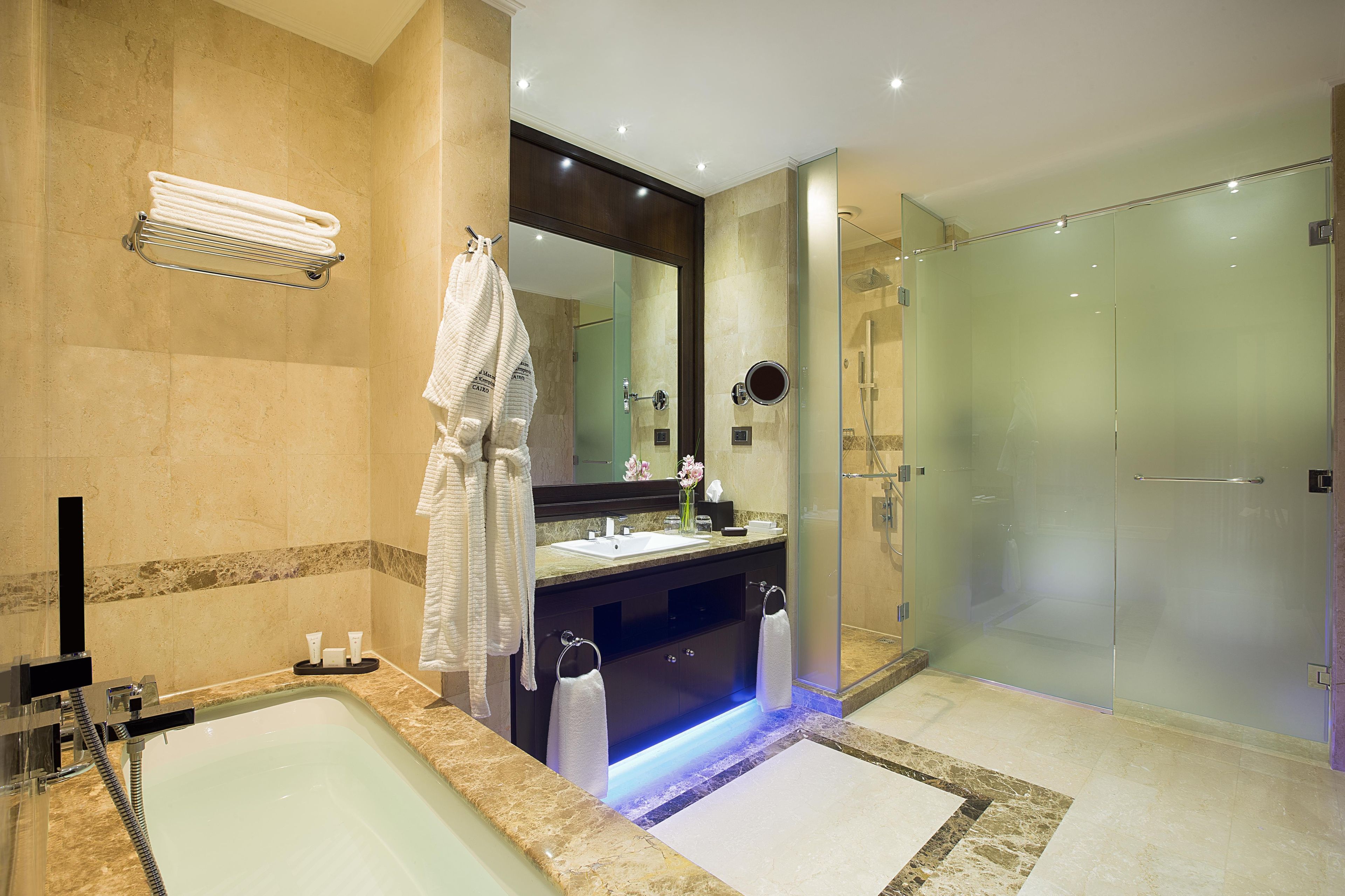 A modern bathroom with a bathtub, a glass-enclosed shower, and a vanity with a mirror.