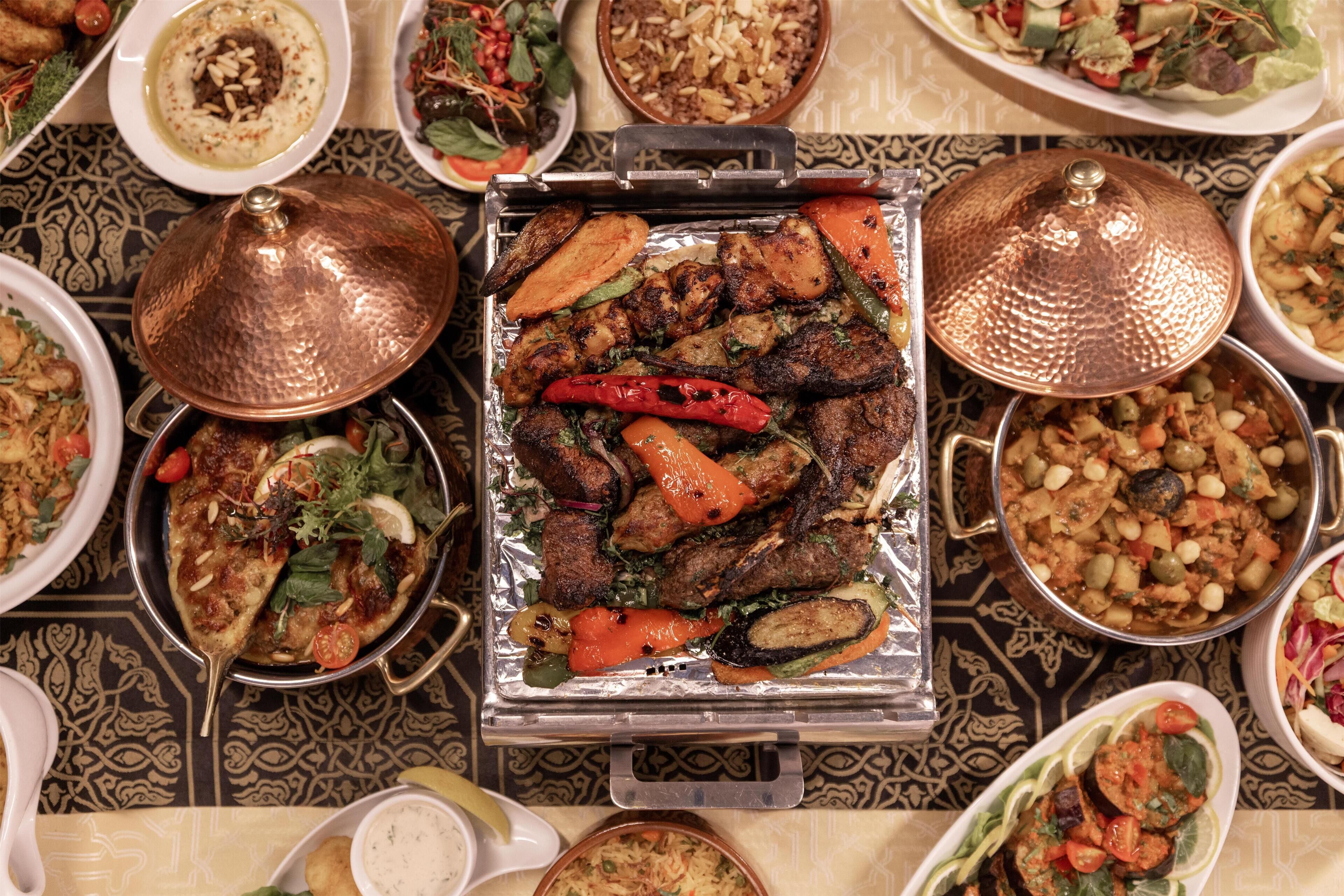 A variety of dishes arranged on a table with a patterned tablecloth.