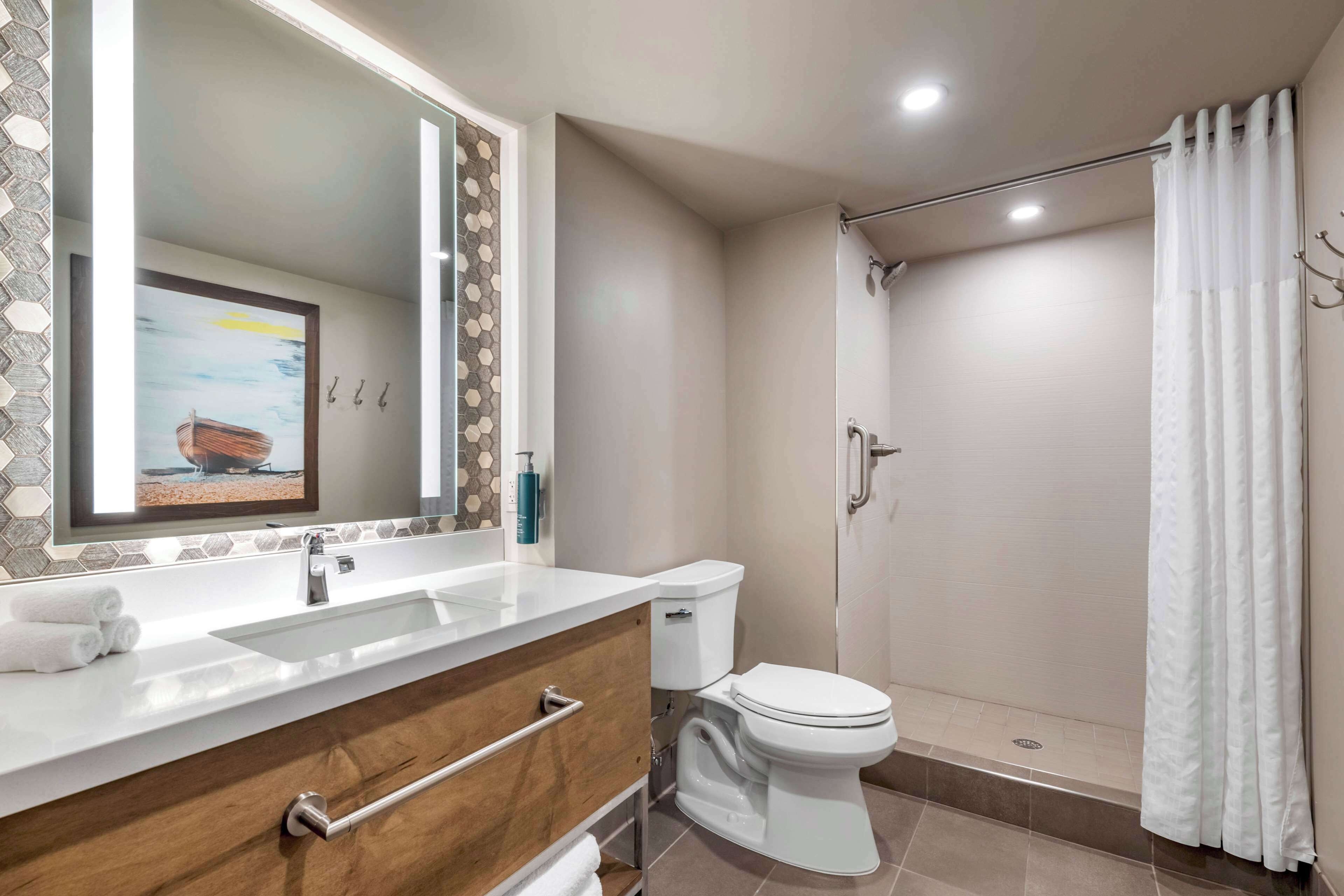 A bathroom with a sink, toilet, and shower.