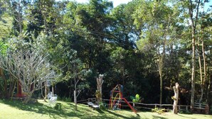 A playground with swings and slides surrounded by trees. - Chácara do Alemão - Recanto Jd.Silvestre (Vargem)